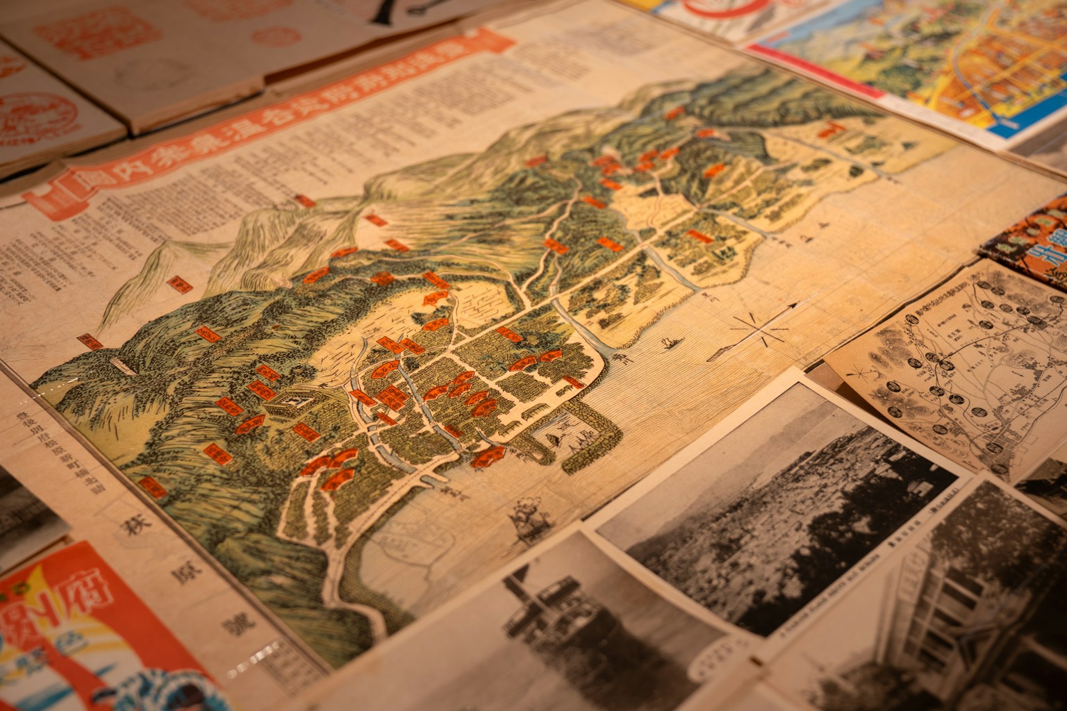 An old map with photos and books surrounding it. (Photo by Marco Vockner on Unsplash)