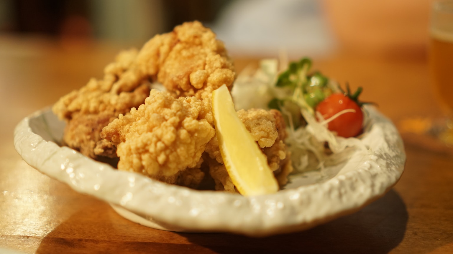 a plate of food on a table with a glass of beer (Photo by ibmoon Kim on Unsplash)