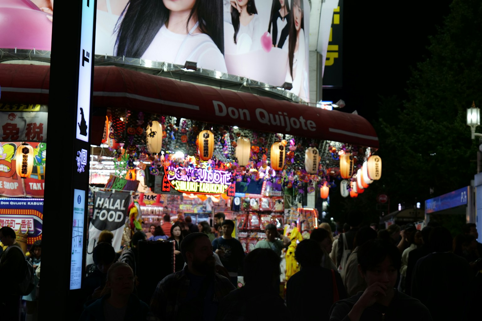 Crowded street market at night with bright signs. (Photo by Ignacio Plaza on Unsplash)