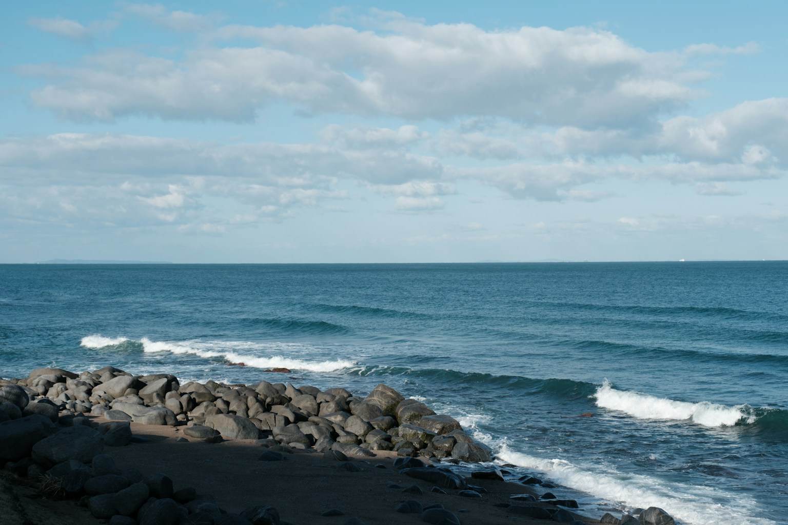 a rocky beach with waves crashing (Photo by urusy on Unsplash)