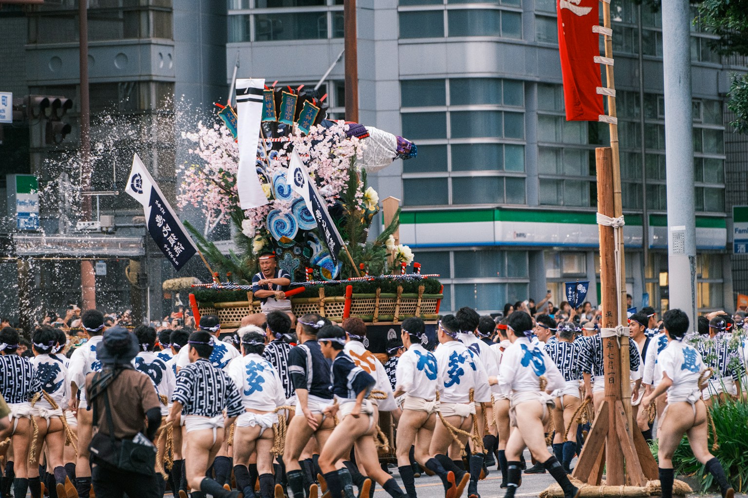 a group of people walking down a street next to tall buildings (Photo by Nichika Sakurai on Unsplash)