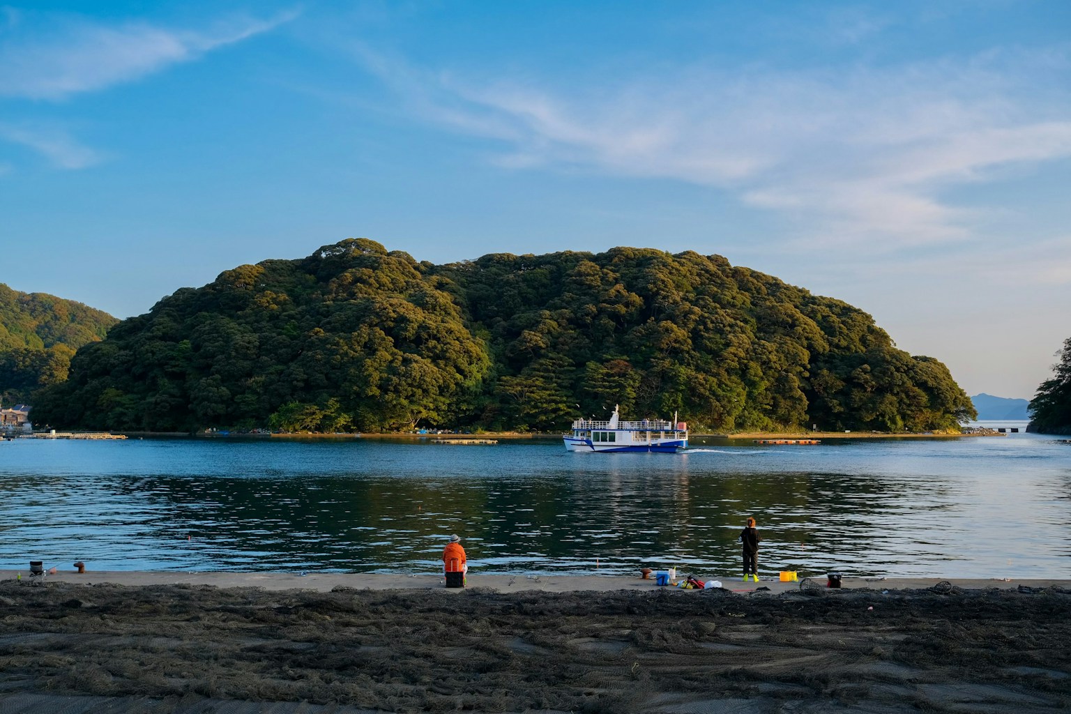 a group of people standing on a beach next to a body of water (Photo by Yusheng Deng on Unsplash)