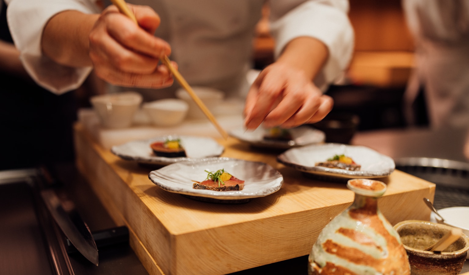 a person holding a chopstick over a plate of food (Photo by Lucas Law on Unsplash)