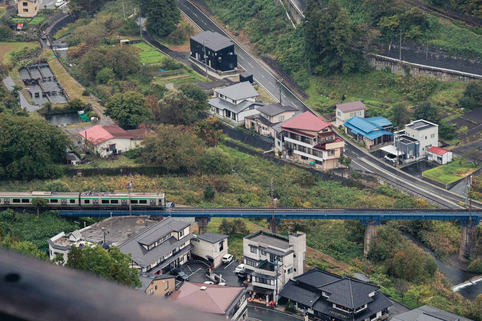 an aerial view of a city with a train on the tracks (Photo by Tuan P. on Unsplash)