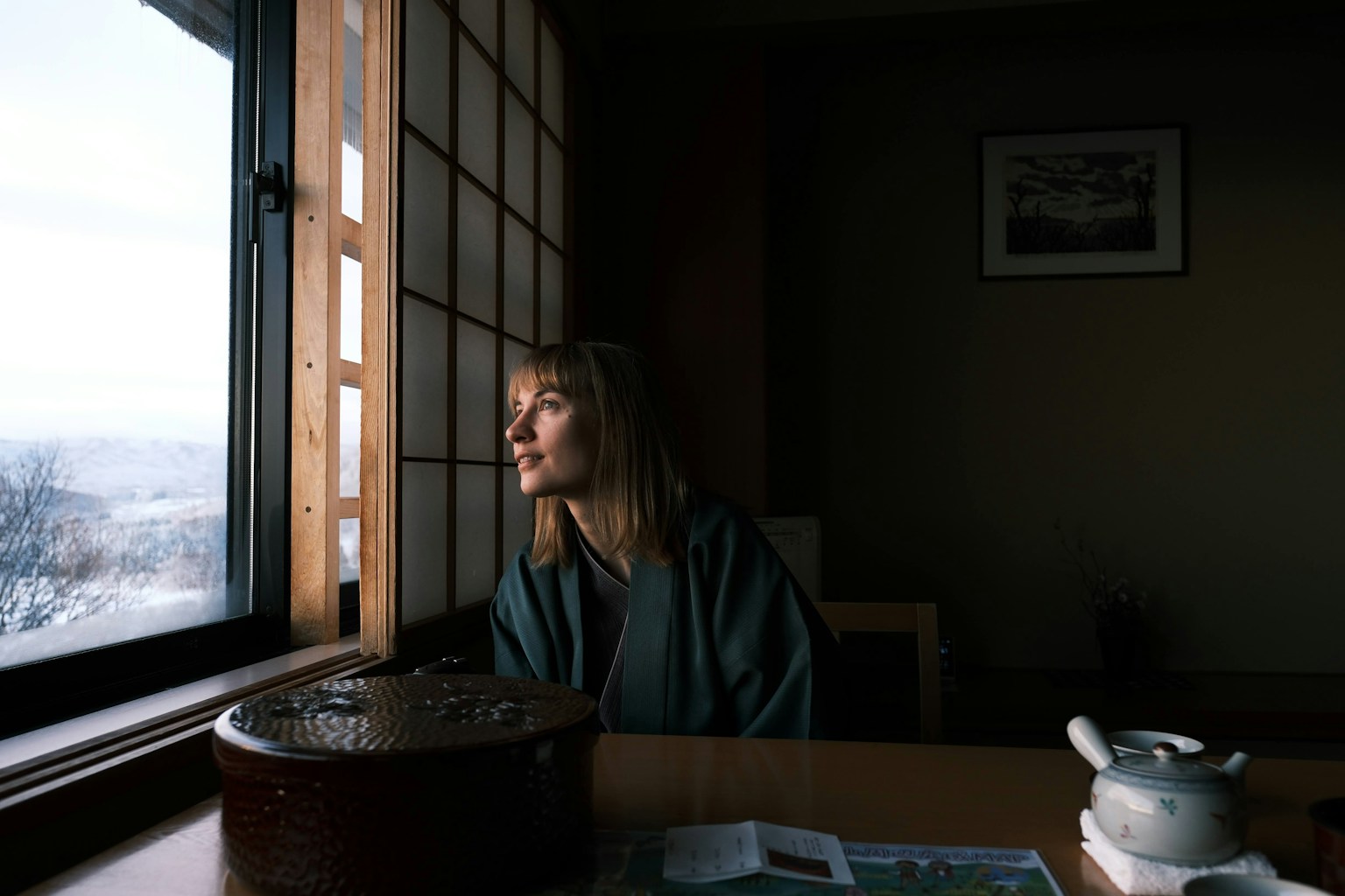 a woman sitting at a table looking out a window (Photo by Seiya Maeda on Unsplash)