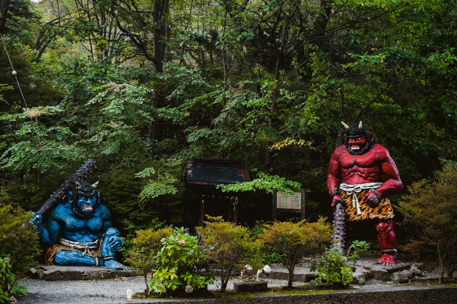 a couple of statues sitting in the middle of a forest (Photo by aestelle on Unsplash)