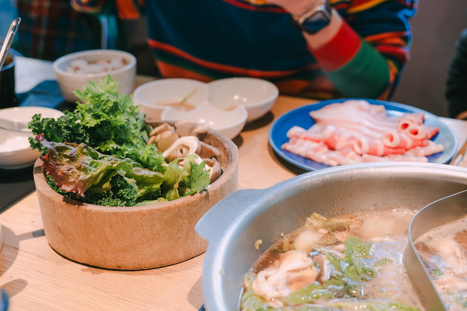 A table laden with ingredients for a hot pot meal. (Photo by Seungmin Yoon on Unsplash)