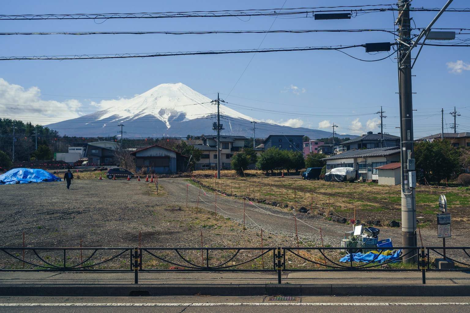 Mount fuji with snow cap overlooking a town (Photo by Red Shuheart on Unsplash)