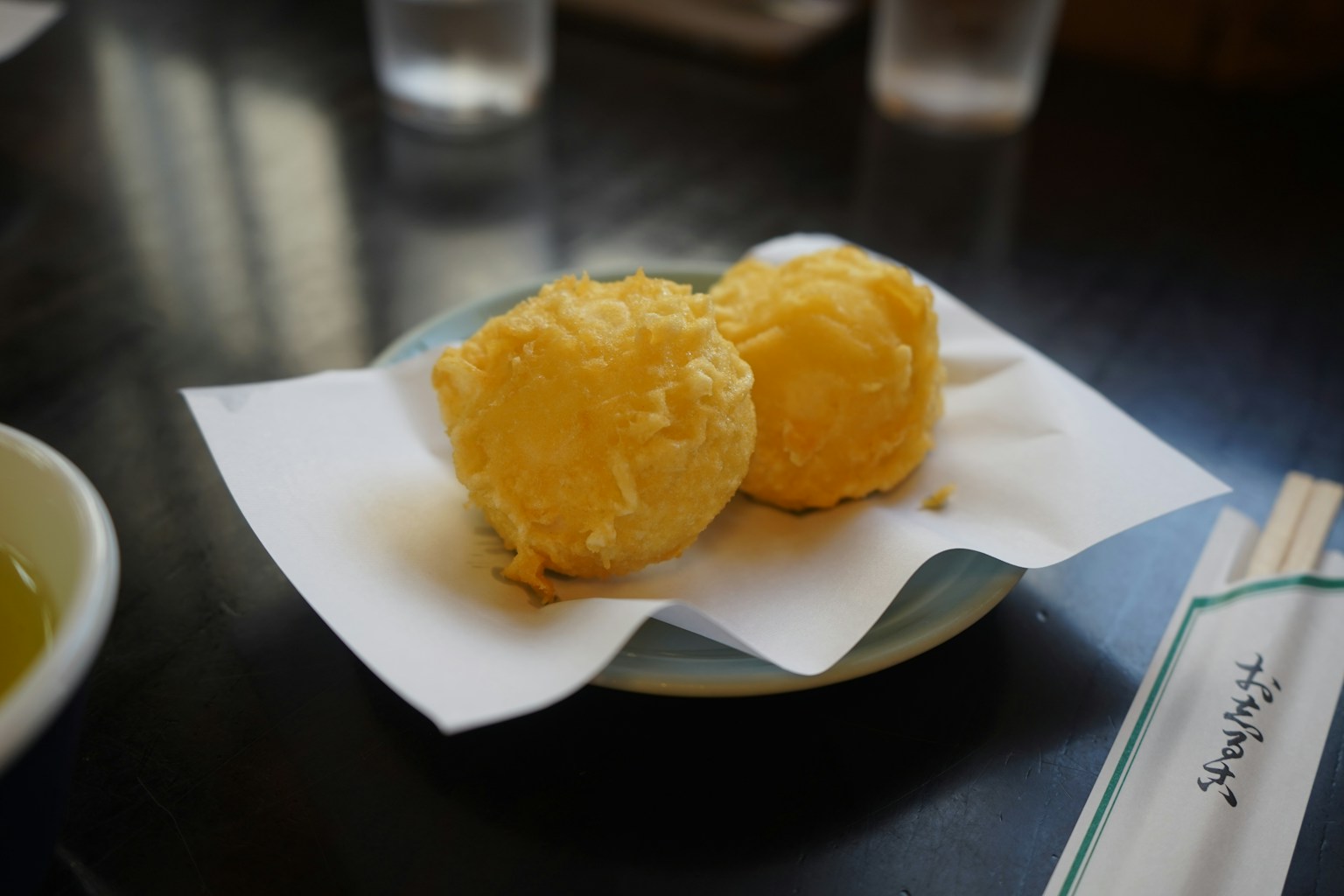 Two golden fried dumplings on a plate (Photo by Yosuke Ota on Unsplash)