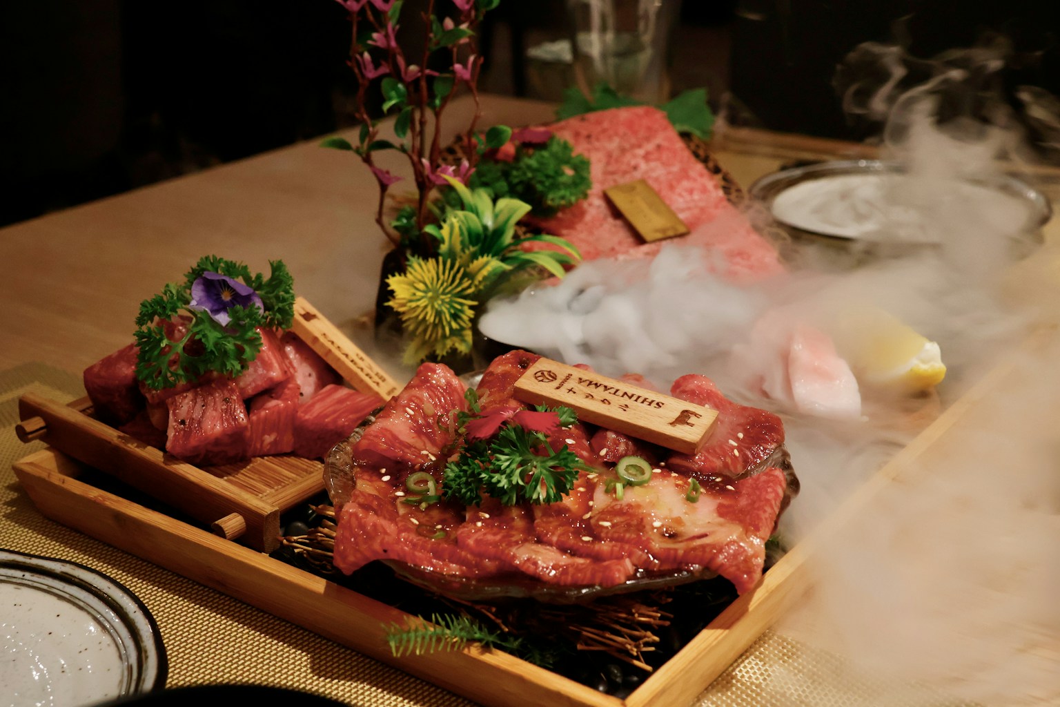 Marbled raw beef cuts arranged on a wooden platter (Photo by You Le on Unsplash)