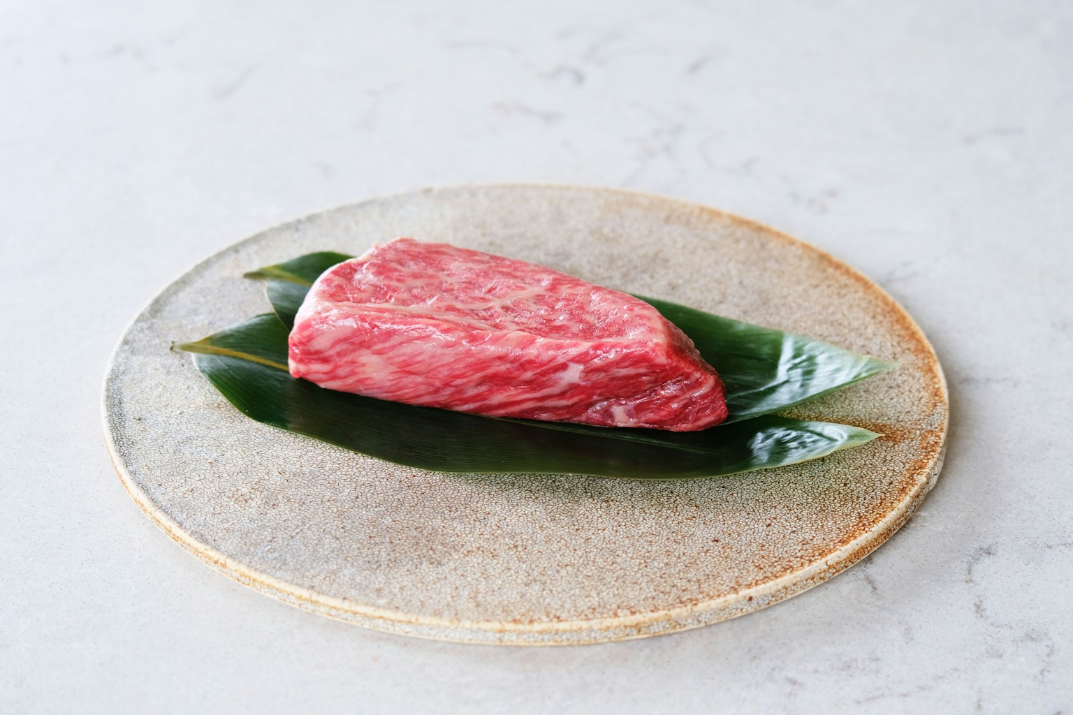 raw meat on white and green floral ceramic plate (Photo by moreau tokyo on Unsplash)