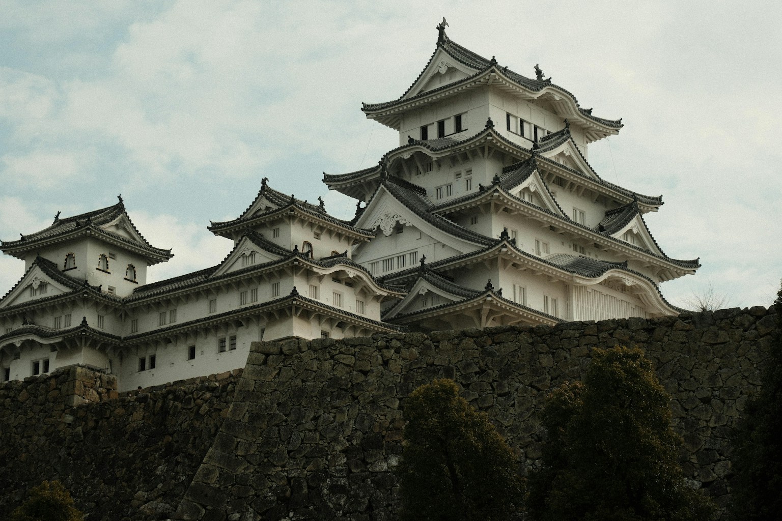 a tall white building sitting on top of a stone wall (Photo by Jose Fabula on Unsplash)