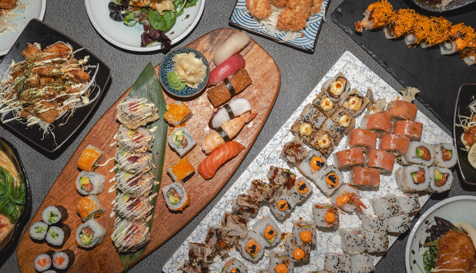 A variety of sushi rolls and nigiri arranged on platters. (Photo by Christopher Yiu Chung on Unsplash)