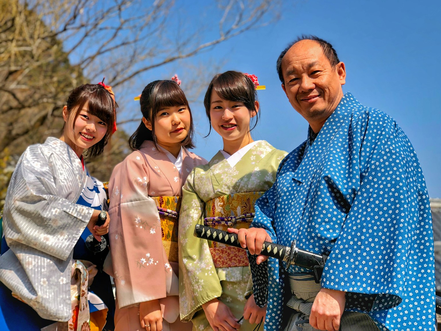 three women wearing kimono beside man holding katana sword (Photo by Justin Lim on Unsplash)