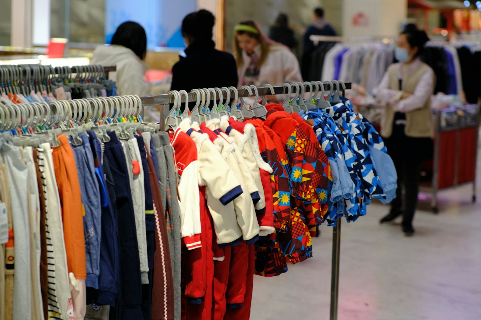 a bunch of clothes hanging on a rack in a store (Photo by kian zhang on Unsplash)