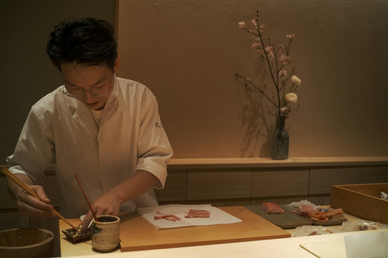 A chef preparing food at a counter (Photo by Lei Hwang on Unsplash)
