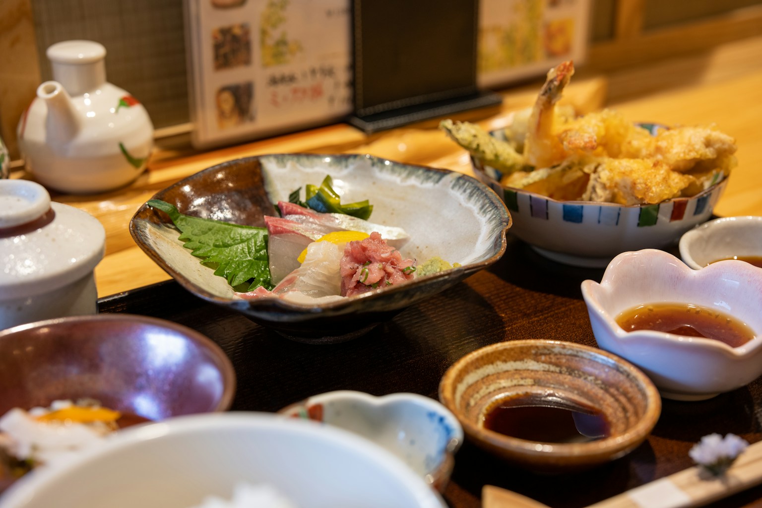 a wooden table topped with bowls of food (Photo by Kouji Tsuru on Unsplash)