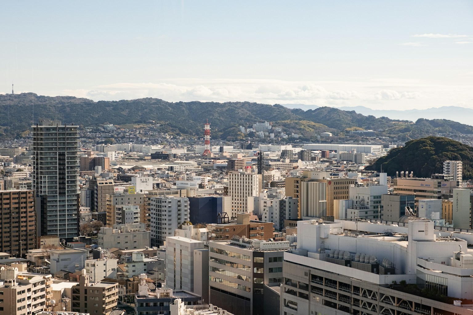 A cityscape with mountains in the background. (Photo by Tuan P. on Unsplash)