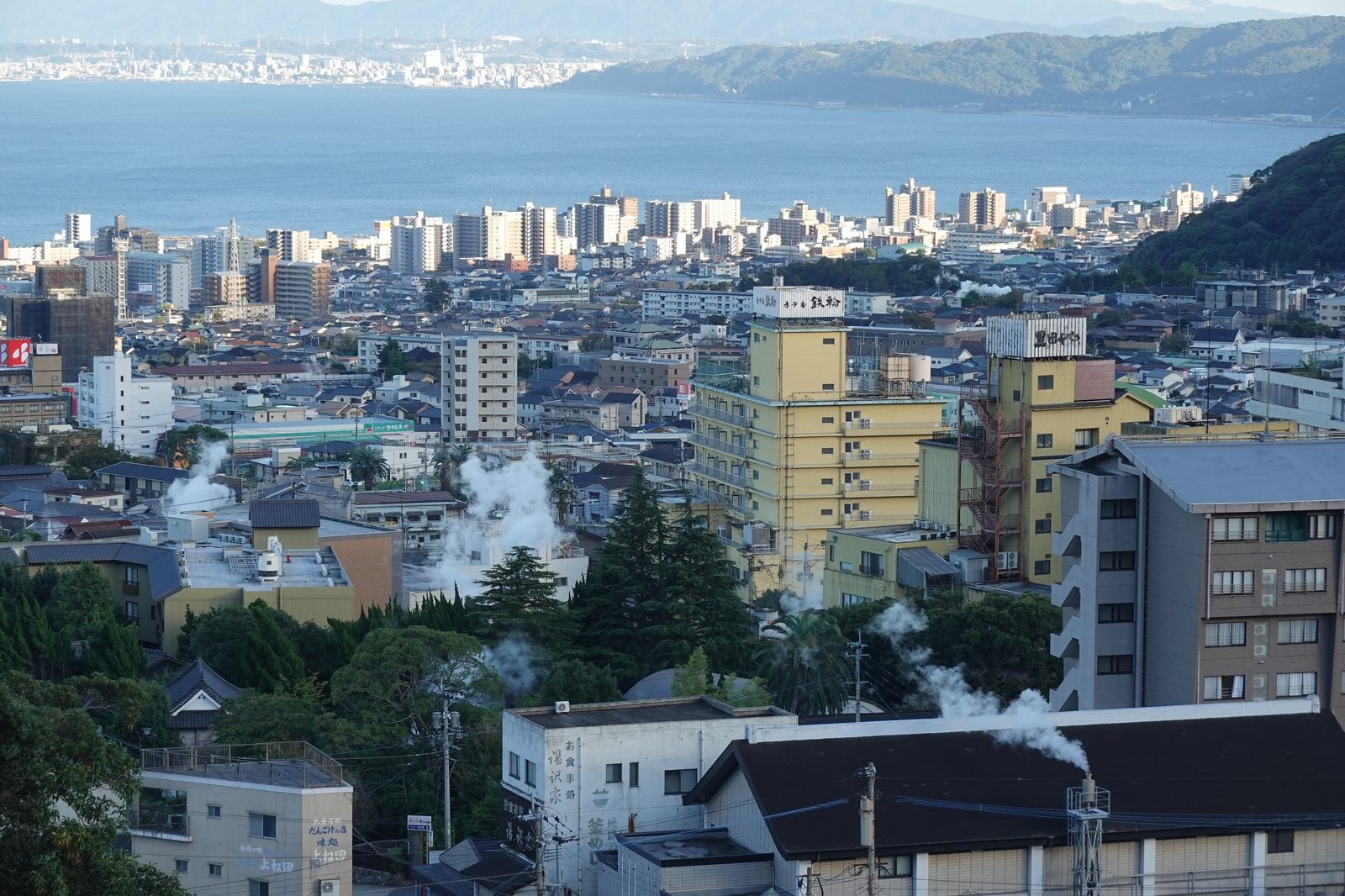 The city of Beppu with onsen steam rising over the bay in Oita