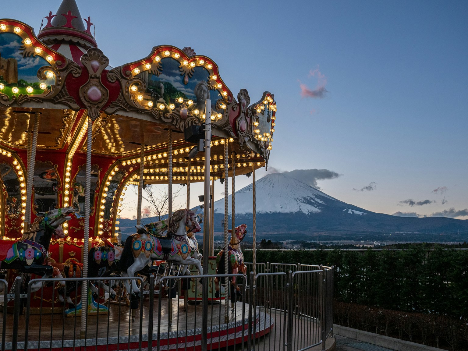 a merry go round with a mountain in the background (Photo by Vicky Ng on Unsplash)