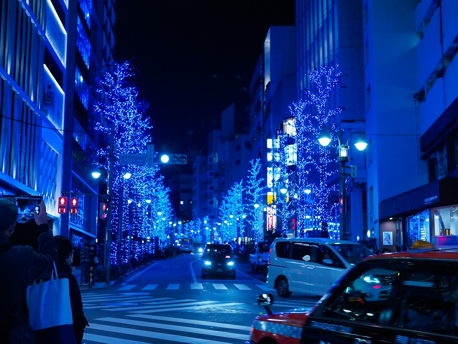 a city street at night with blue christmas lights (Photo by Yuika Takamura on Unsplash)