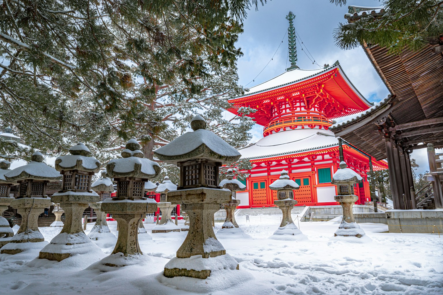 red and white temple surrounded by trees covered with snow (Photo by Samuel Berner on Unsplash)