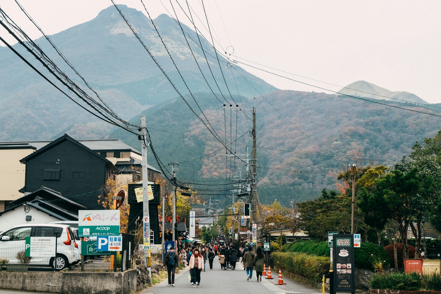 people walking on street near buildings and mountain during daytime (Photo by Tayawee Supan on Unsplash)