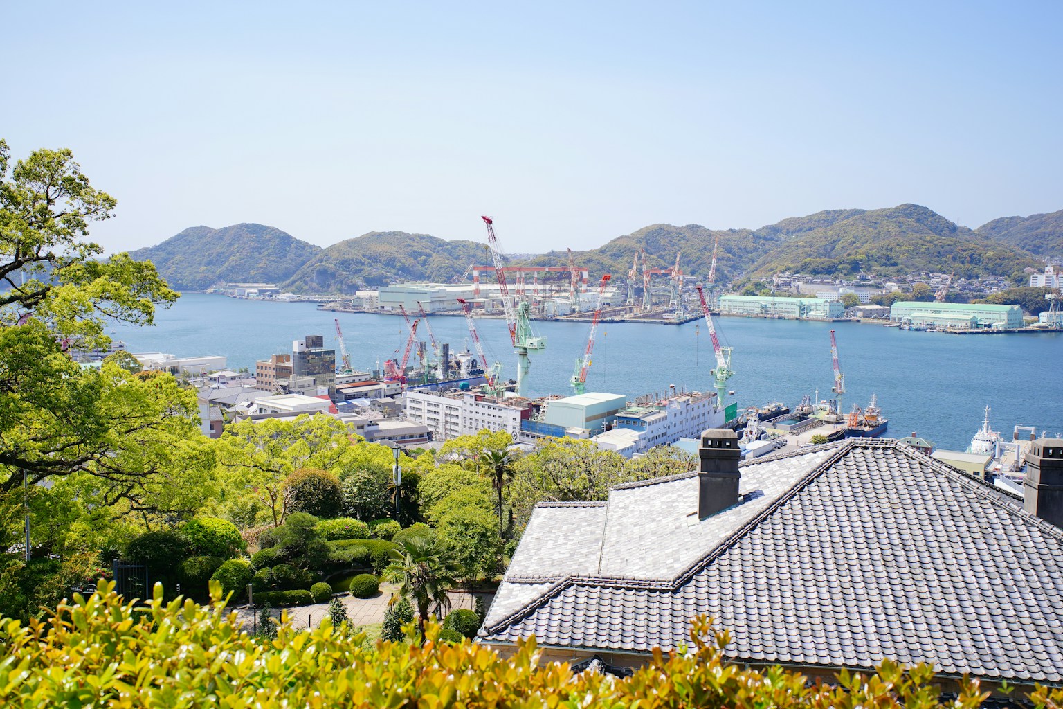 Cityscape with a bay, shipyard, and mountains (Photo by Zion C on Unsplash)