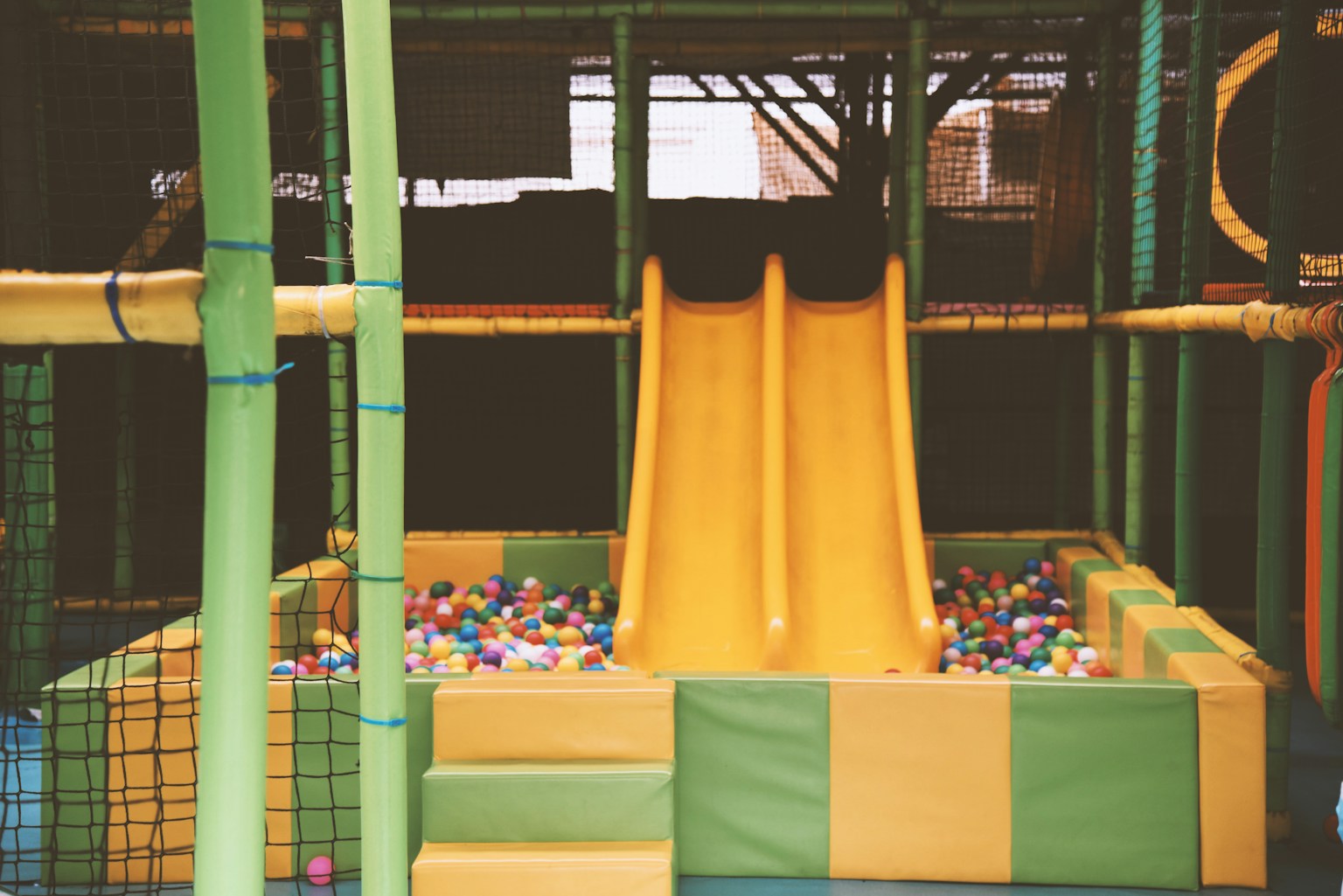 a green cage with a yellow cloth from it (Photo by Luna Wang on Unsplash)