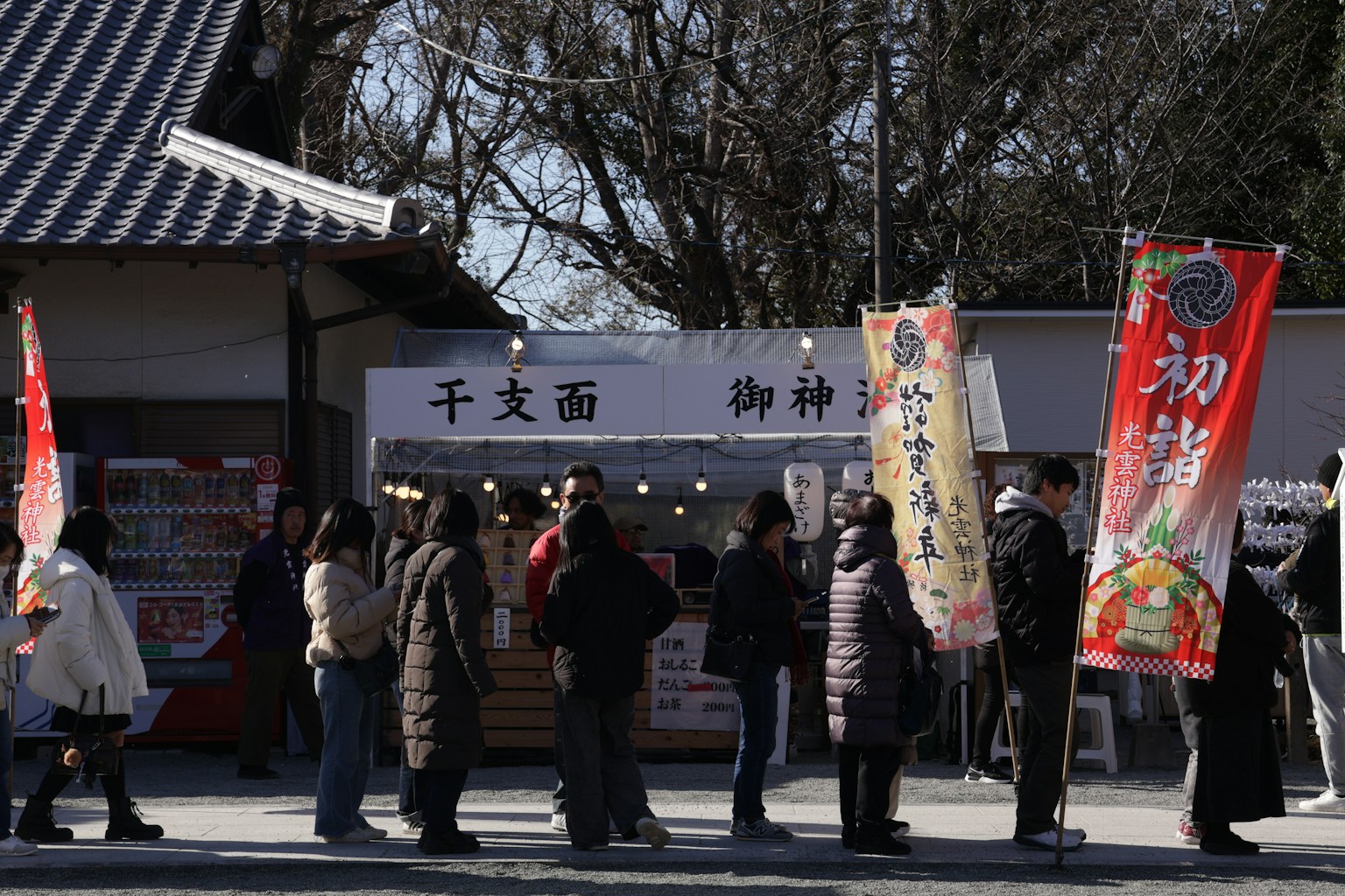 People queue at a food stall with banners (Photo by Yanhao Fang on Unsplash)