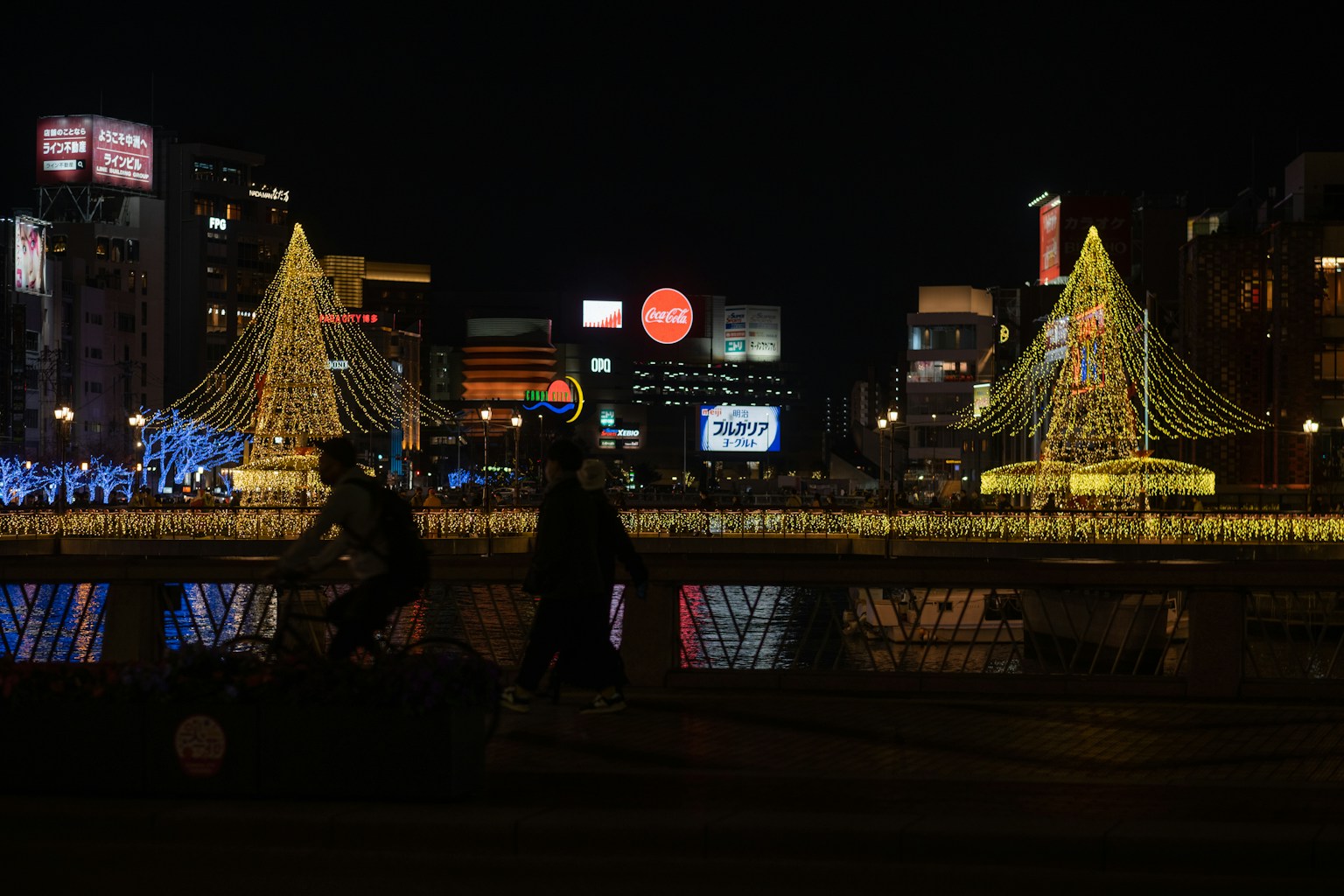 a group of people sitting on a bridge with lights (Photo by Nichika Sakurai on Unsplash)