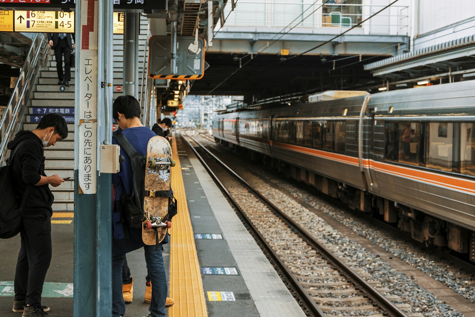 a couple of people standing next to a train (Photo by Rafael Hoyos Weht on Unsplash)